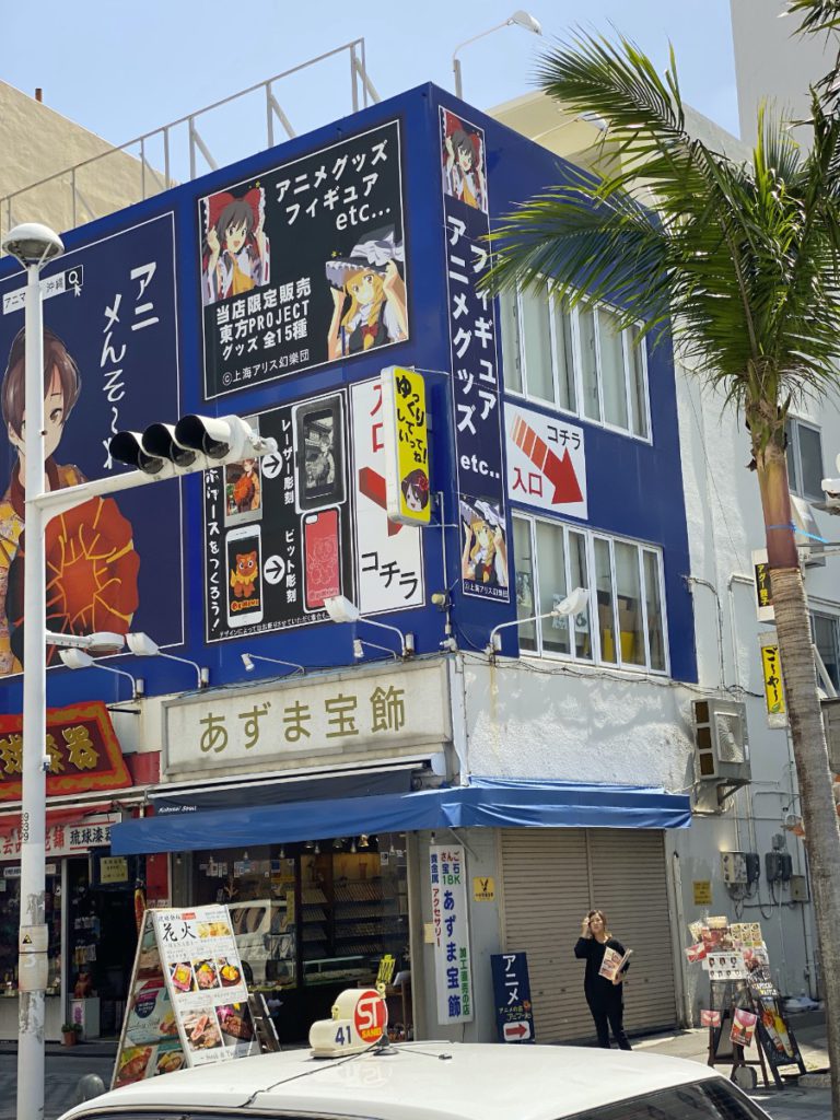 A side view of the Anima-ru anime store sign showing arrows pointing down an alley